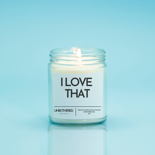 I Love That Candle from the Unbothered Candle Co. Available in two Limited Edition Scents Pine Tree*, Holly Berry*, and two signature scents Cinnamon Roll and Vanilla Cookie. Vegan Soy Coconut Wax, 100% Cotton Wick, Hand-poured in the USA, Eco-friendly, non-toxic, no lead, no parabens, no synthetic dyes, no phthalates, and NEVER tested on animals.