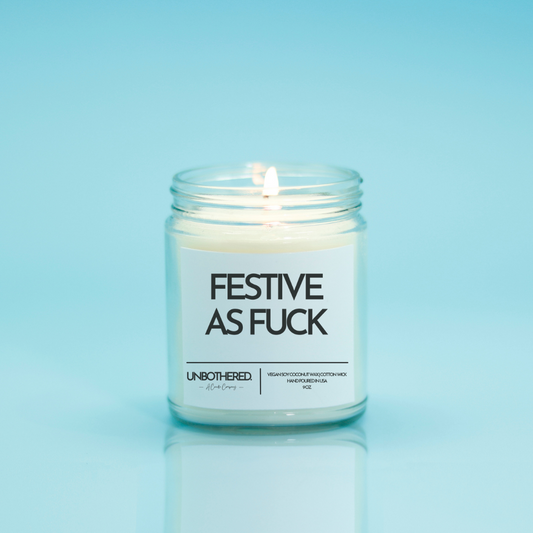 Festive As Fuck Candle from the Unbothered Candle Co. Available in two Limited Edition Scents Pine Tree*, Holly Berry*, and two signature scents Cinnamon Roll and Vanilla Cookie. Vegan Soy Coconut Wax, 100% Cotton Wick, Hand-poured in the USA, Eco-friendly, non-toxic, no lead, no parabens, no synthetic dyes, no phthalates, and NEVER tested on animals.