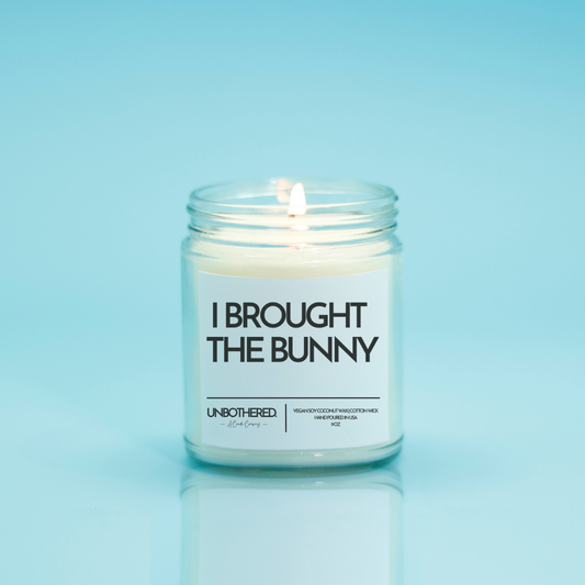 I Brought The Bunny Candle from the Unbothered Candle Co. Available in two Limited Edition Scents Pine Tree*, Holly Berry*, and two signature scents Cinnamon Roll and Vanilla Cookie. Vegan Soy Coconut Wax, 100% Cotton Wick, Hand-poured in the USA, Eco-friendly, non-toxic, no lead, no parabens, no synthetic dyes, no phthalates, and NEVER tested on animals.