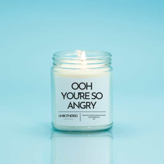Ooh You're So Angry Candle from the Unbothered Candle Co. Available in two Limited Edition Scents Pine Tree*, Holly Berry*, and two signature scents Cinnamon Roll and Vanilla Cookie. Vegan Soy Coconut Wax, 100% Cotton Wick, Hand-poured in the USA, Eco-friendly, non-toxic, no lead, no parabens, no synthetic dyes, no phthalates, and NEVER tested on animals.