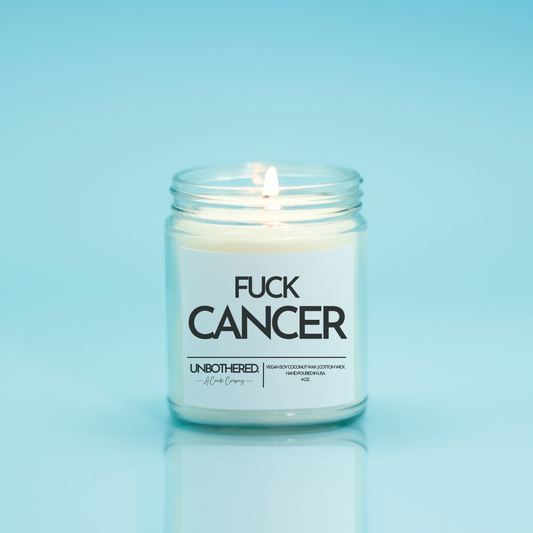 Fuck Cancer Candle from the Unbothered Candle Co. Available in two Limited Edition Scents Pine Tree*, Holly Berry*, and two signature scents Cinnamon Roll and Vanilla Cookie. Vegan Soy Coconut Wax, 100% Cotton Wick, Hand-poured in the USA, Eco-friendly, non-toxic, no lead, no parabens, no synthetic dyes, no phthalates, and NEVER tested on animals.