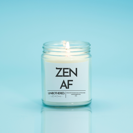 Zen AF Candle from the Unbothered Candle Co. Available in two Limited Edition Scents Pine Tree*, Holly Berry*, and two signature scents Cinnamon Roll and Vanilla Cookie. Vegan Soy Coconut Wax, 100% Cotton Wick, Hand-poured in the USA, Eco-friendly, non-toxic, no lead, no parabens, no synthetic dyes, no phthalates, and NEVER tested on animals.